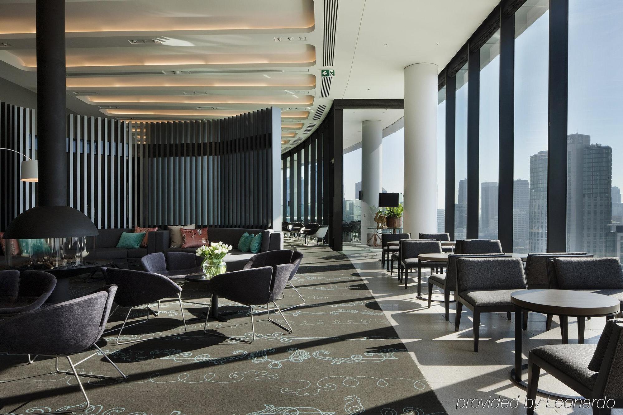 Hotel Crown Metropol Melbourne Esterno foto The photo depicts a modern and stylish lounge or café area. It features large windows that allow plenty of natural light to flood the space, offering a panoramic view of the city. The interior design includes a combination of comfortable seating arra