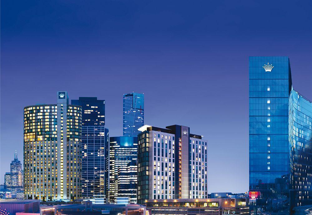 Hotel Crown Metropol Melbourne Esterno foto The photo showcases a city skyline at dusk, featuring a cluster of modern high-rise buildings and skyscrapers. The structures are illuminated against the evening sky, creating a vibrant atmosphere. Prominently displayed on the right is a tall buildin