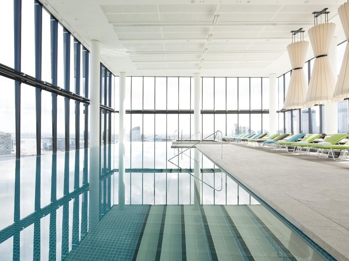 Hotel Crown Metropol Melbourne Esterno foto The photo shows a modern indoor swimming pool area characterized by large floor-to-ceiling windows that allow natural light to fill the space. The water in the pool is calm and reflects the surroundings, creating a serene atmosphere. There are steps 