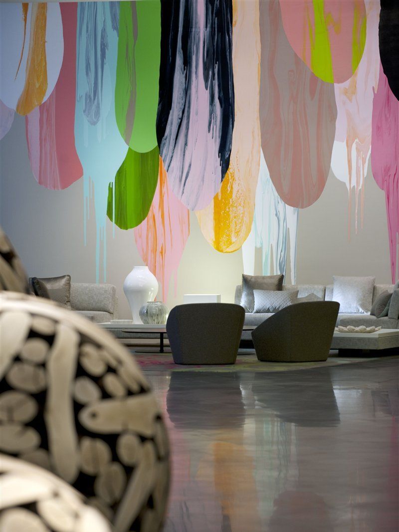 Hotel Crown Metropol Melbourne Esterno foto The photo shows a modern interior space featuring contemporary furniture and a striking wall mural. The mural consists of colorful paint drips in shades of pink, green, yellow, and black, creating an artistic backdrop. In the foreground, there are tw